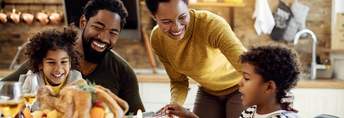 Thanksgiving Dinner - Family at the table with a turkey, wine glasses and a candle