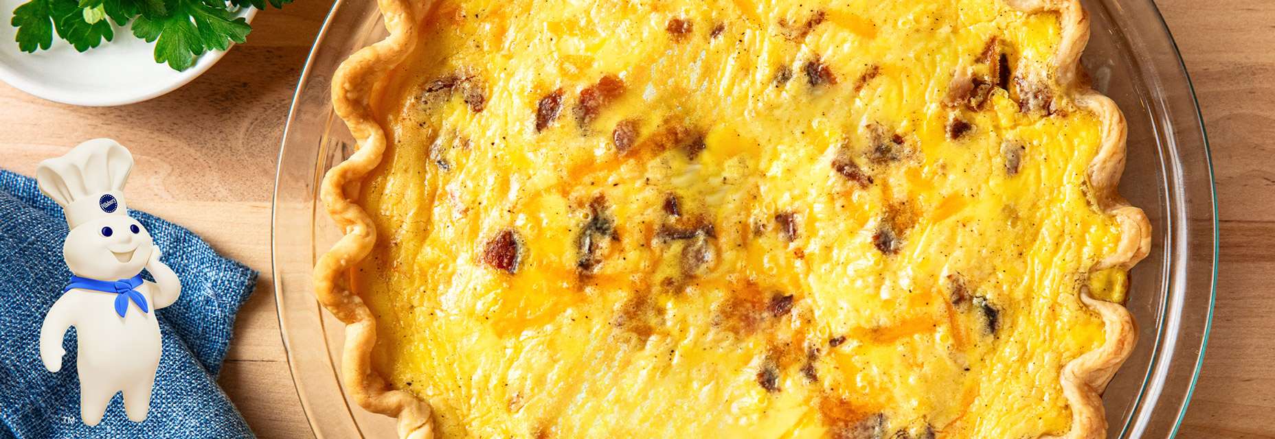 A baked quiche with a golden crust in a pie dish.