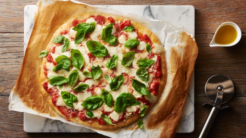 Classic Margherita Pizza prepared recipe topped with fresh basil 