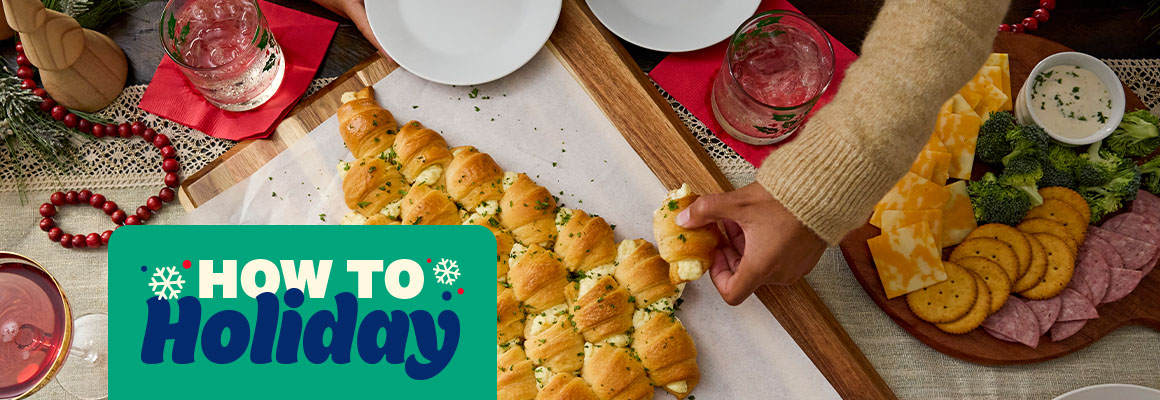 How to holiday. Stuffed crescent rolls placed in the shape of a Christmas tree on a wood board.